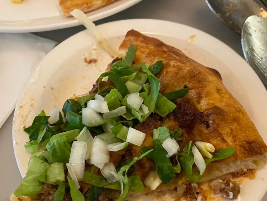 A slice of the Pickles beef cheeseburger pizza