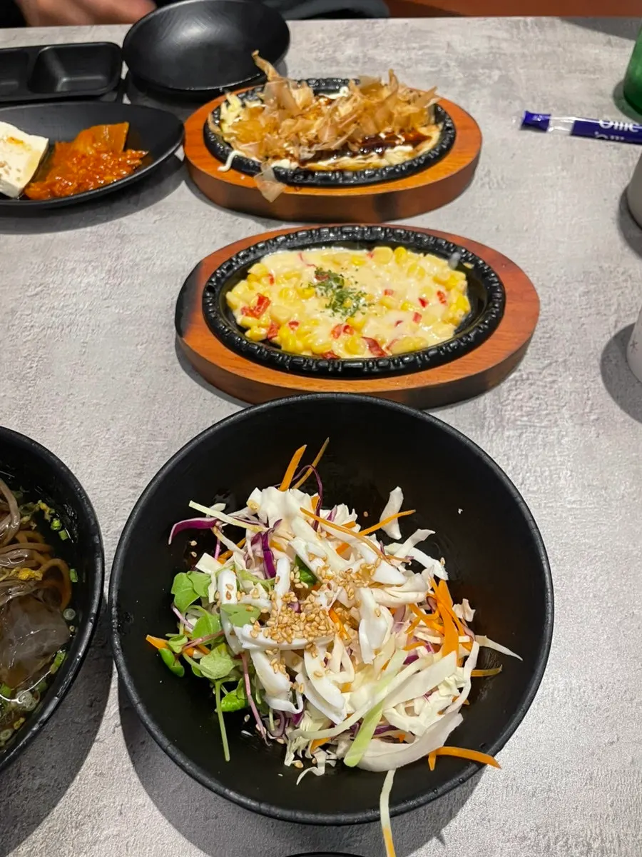 Assorted side dishes including tofu kimchi and sundae