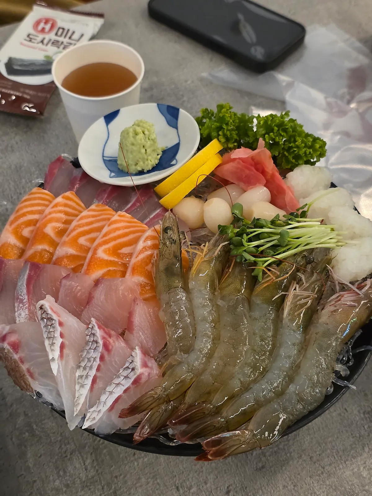 Mixed sashimi platter topped with live raw shrimp
