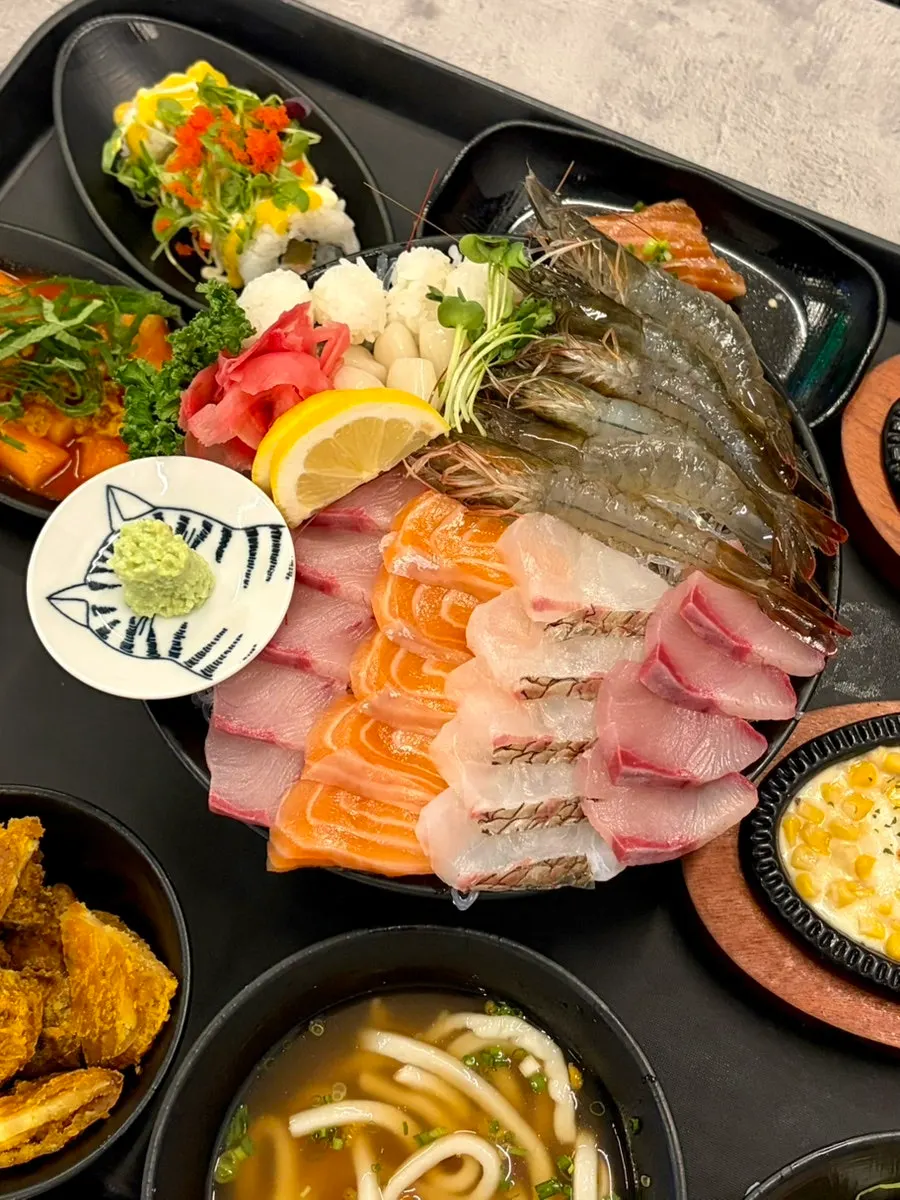 Plate of raw shrimp sashimi and assorted sashimi served at the table