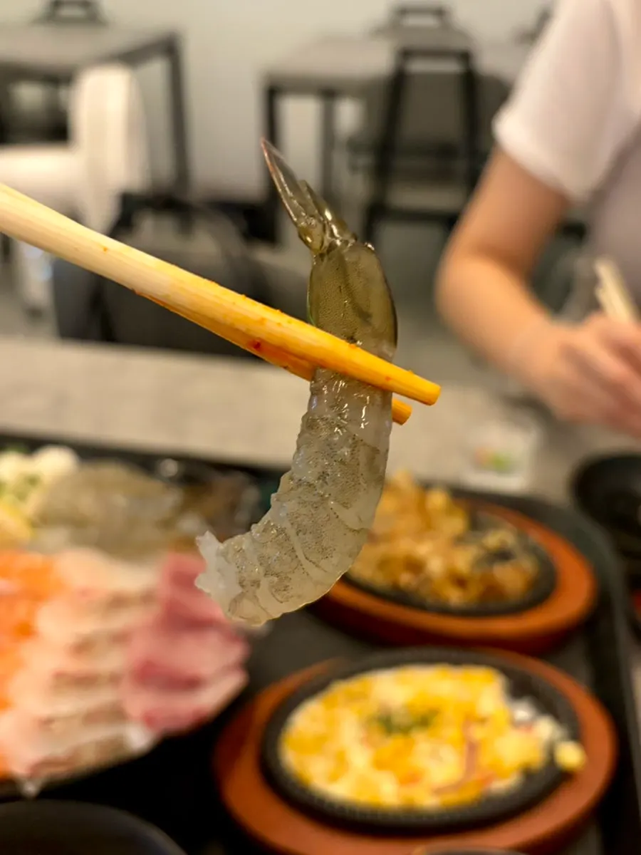 A piece of peeled raw shrimp sashimi