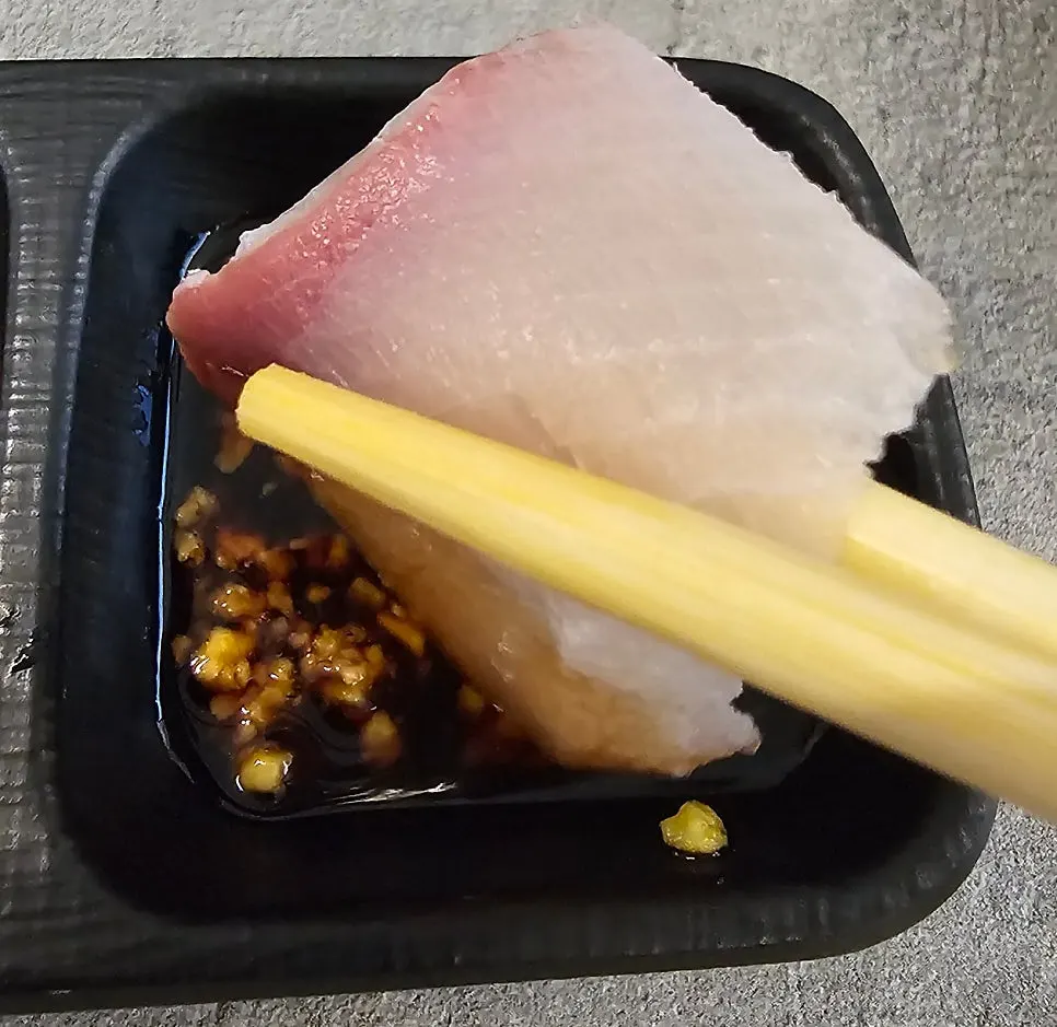 Plate of soy sauce mixed with wasabi next to the aged sashimi