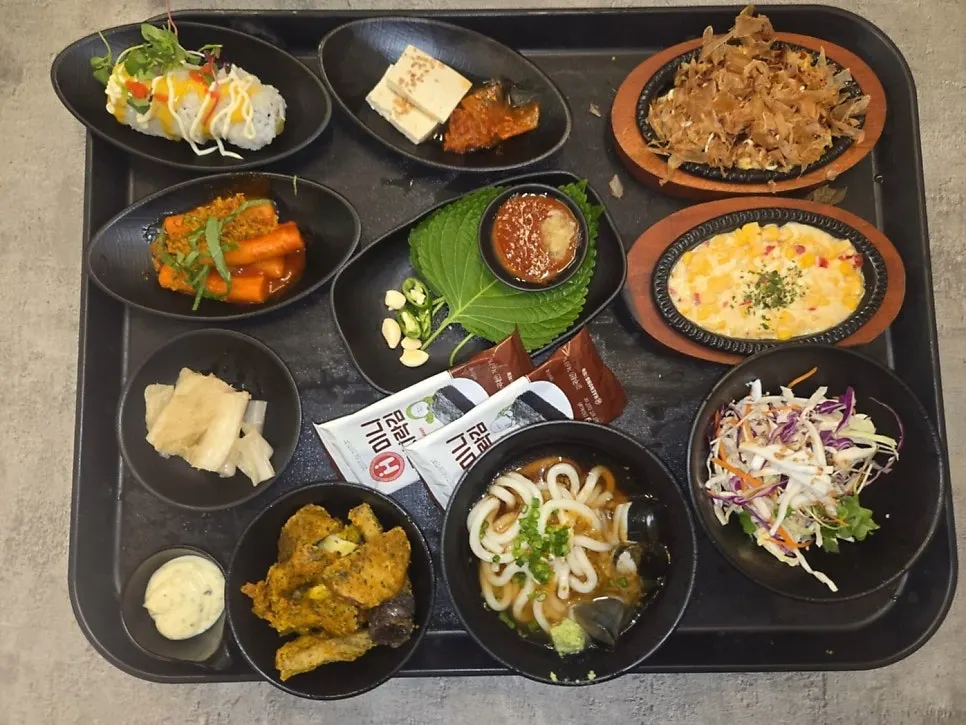 Plates of corn cheese and tteokbokki from the base spread
