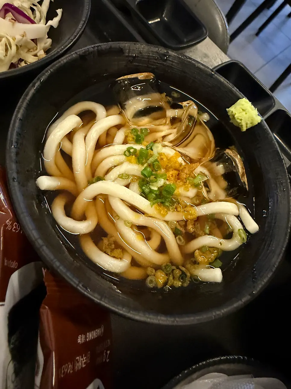Roll topped with flying fish roe alongside cold udon