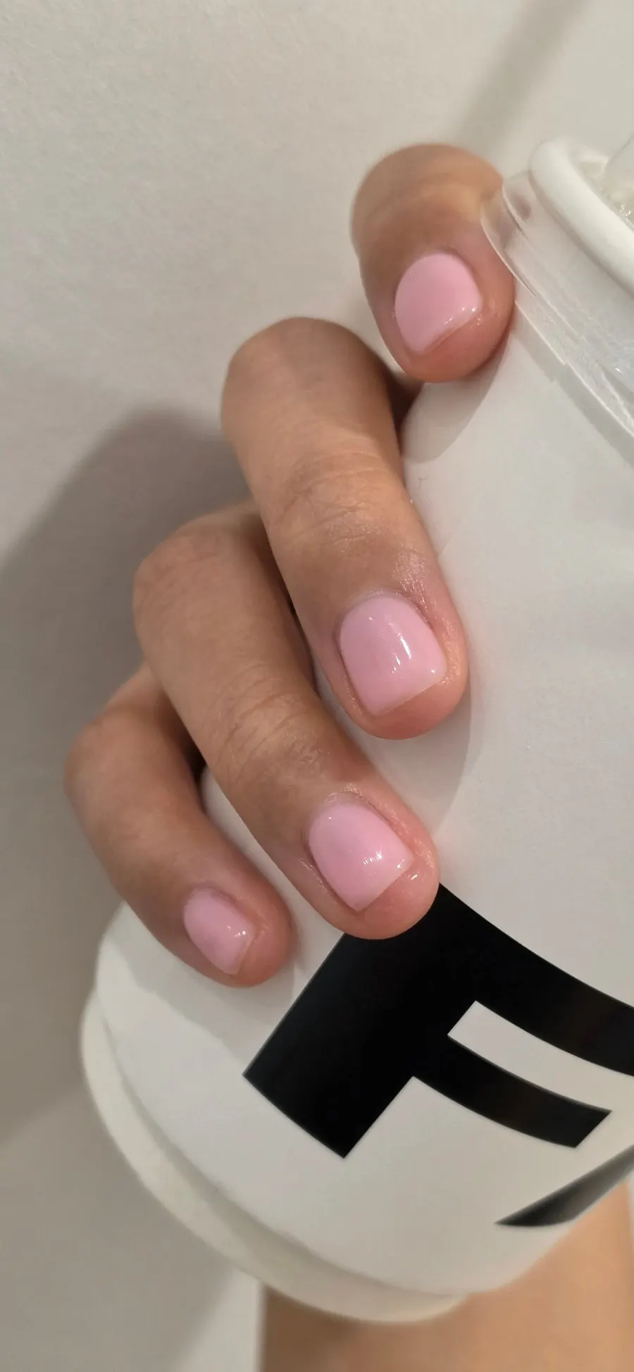 Strawberry milk pink nails seen under indoor lighting
