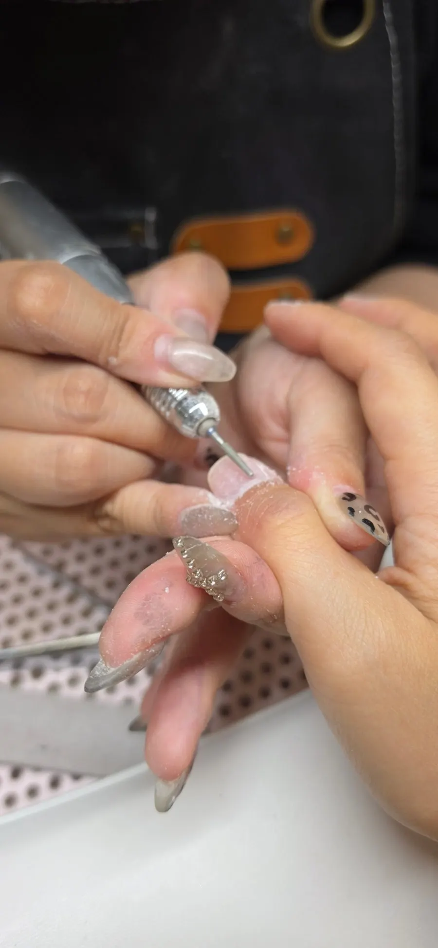 Trying nail shape samples against the hand to choose