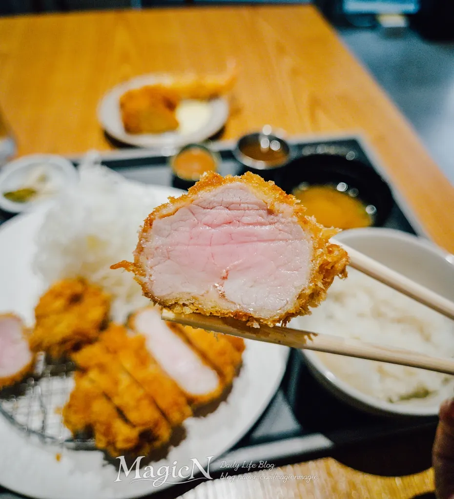 Chopsticks holding a piece of tenderloin katsu