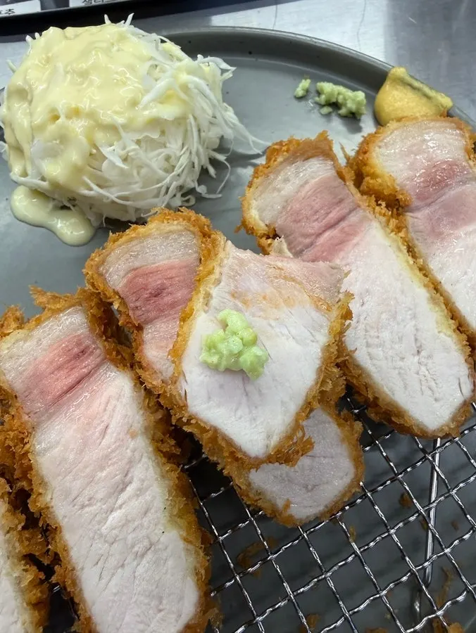 Piece of loin katsu topped with tonkatsu sauce and wasabi