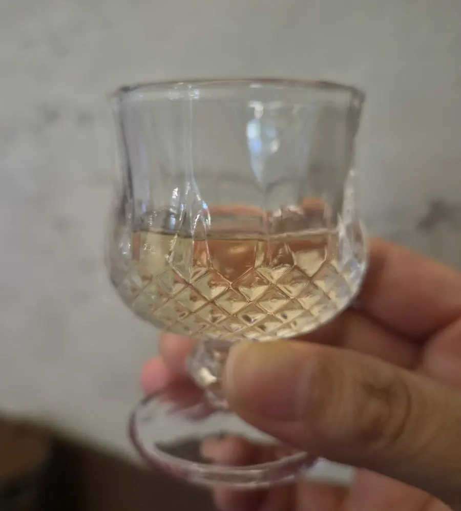 A glass of gamjasul (potato liquor) served as the welcome drink