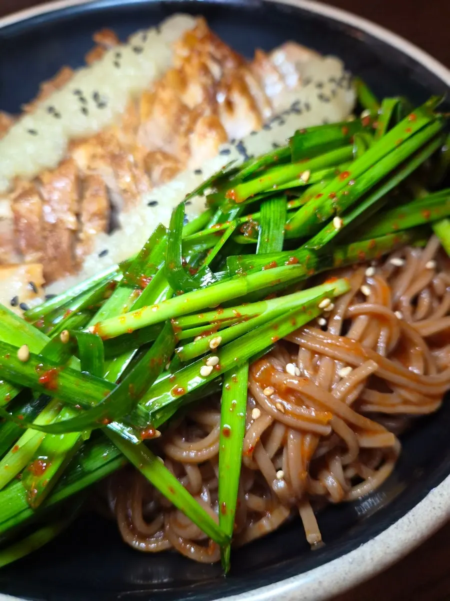 A bite of makguksu with tangy sauce