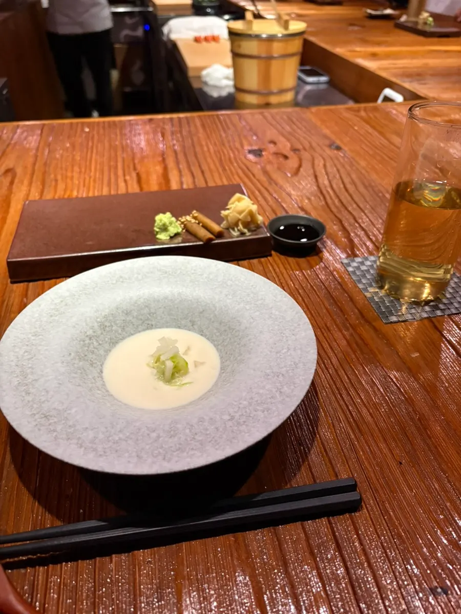 Table setting of green tea, fresh wasabi, and braised burdock root
