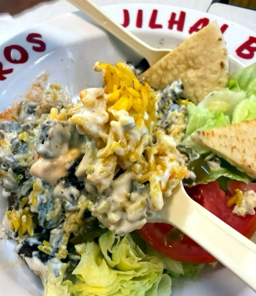 Combo rice plate topped with white sauce and red sauce