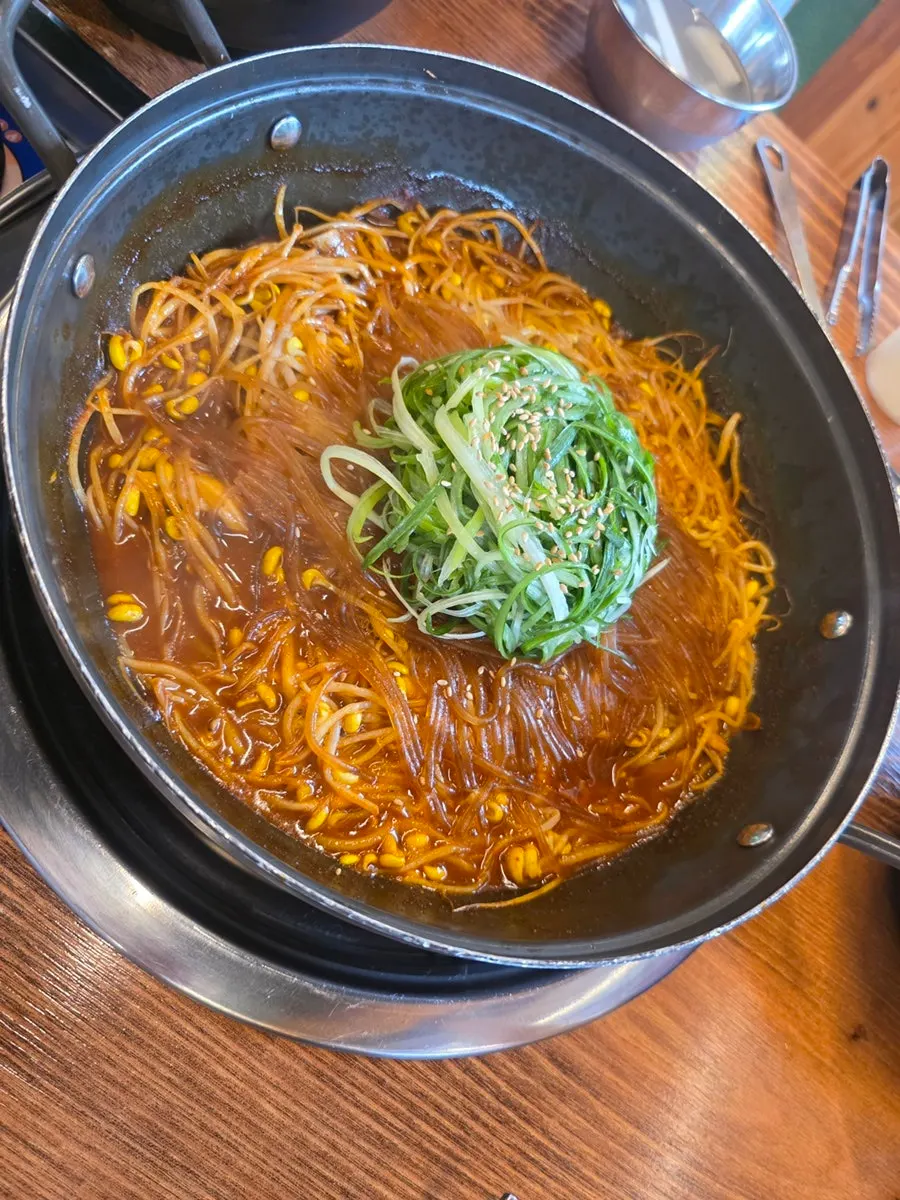 Spicy braised pork ribs topped with bean sprouts and glass noodles