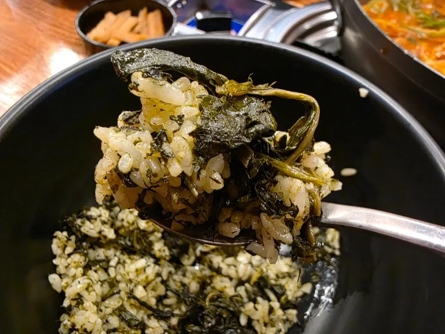 A spoonful of gondre rice packed with thistle greens