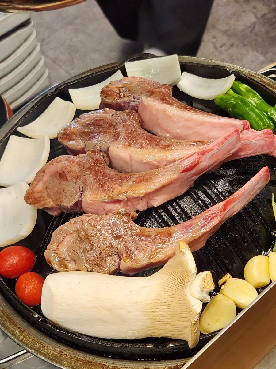 Staff grilling French rack on the tabletop grill