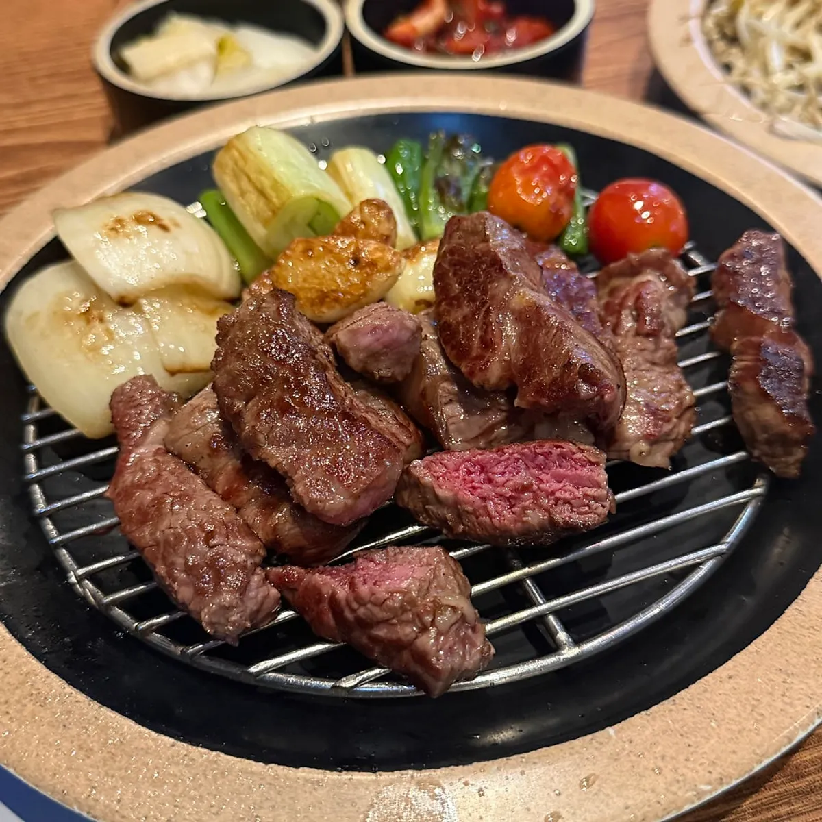 Lamb chops grilling together with mushrooms and vegetables