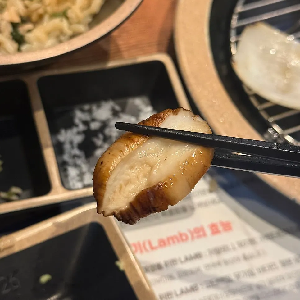 A piece of lamb with salt and wasabi on the side
