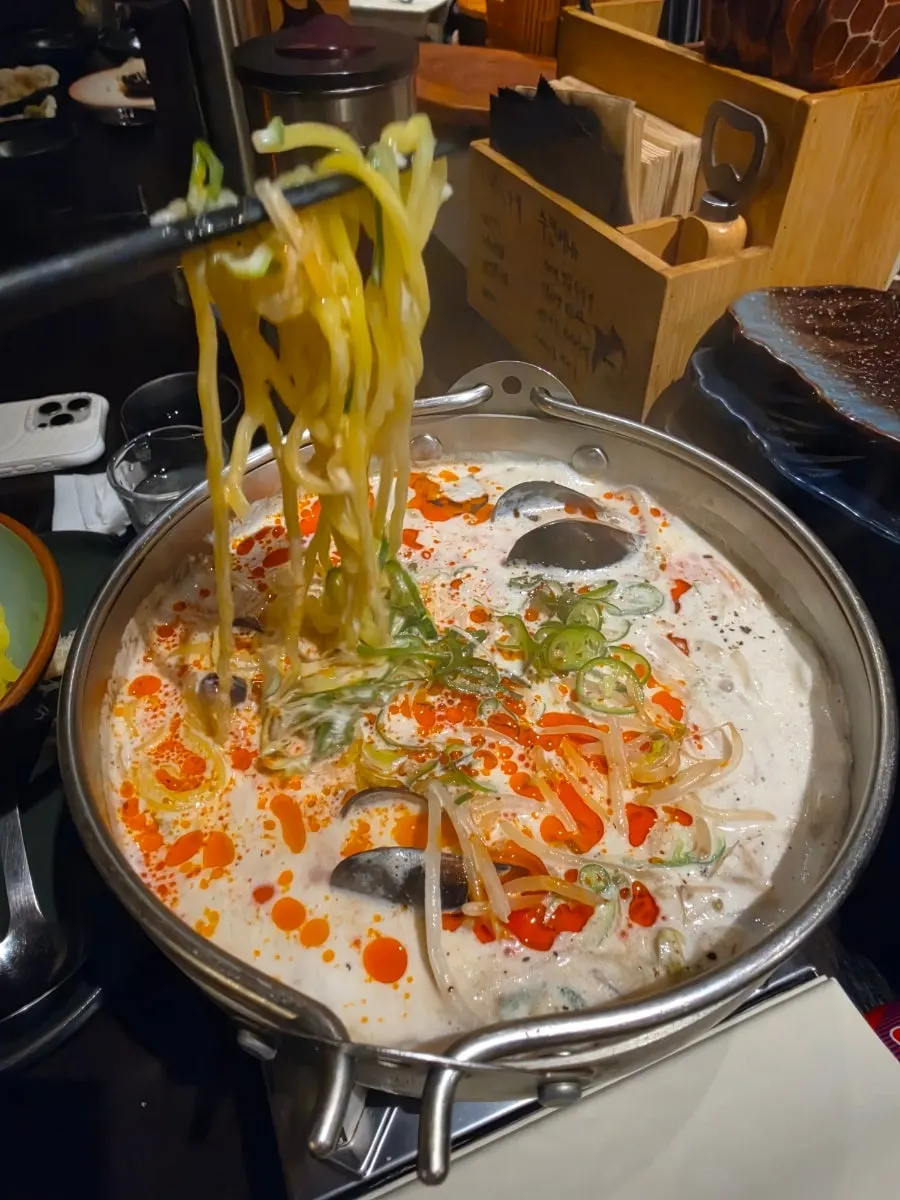 Adding noodles into the cream jjamppong bit by bit