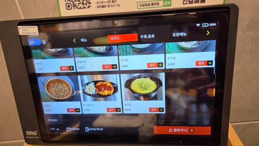 Kiosk screen showing add-in options like glass noodles, mushrooms, and rice cake