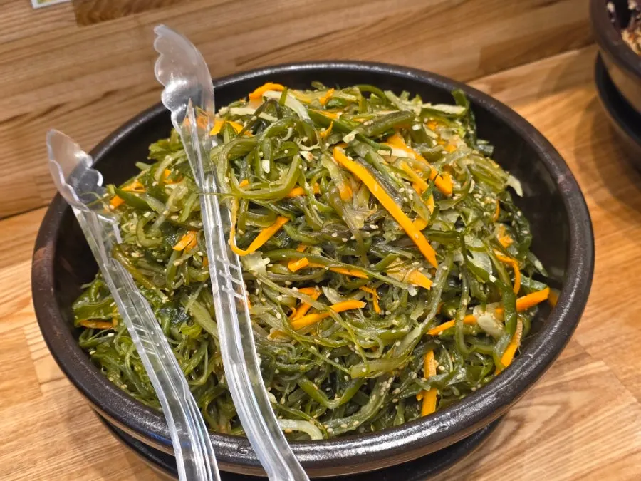 Side dishes of napa cabbage kimchi, white kimchi, seaweed stems and bracken fern