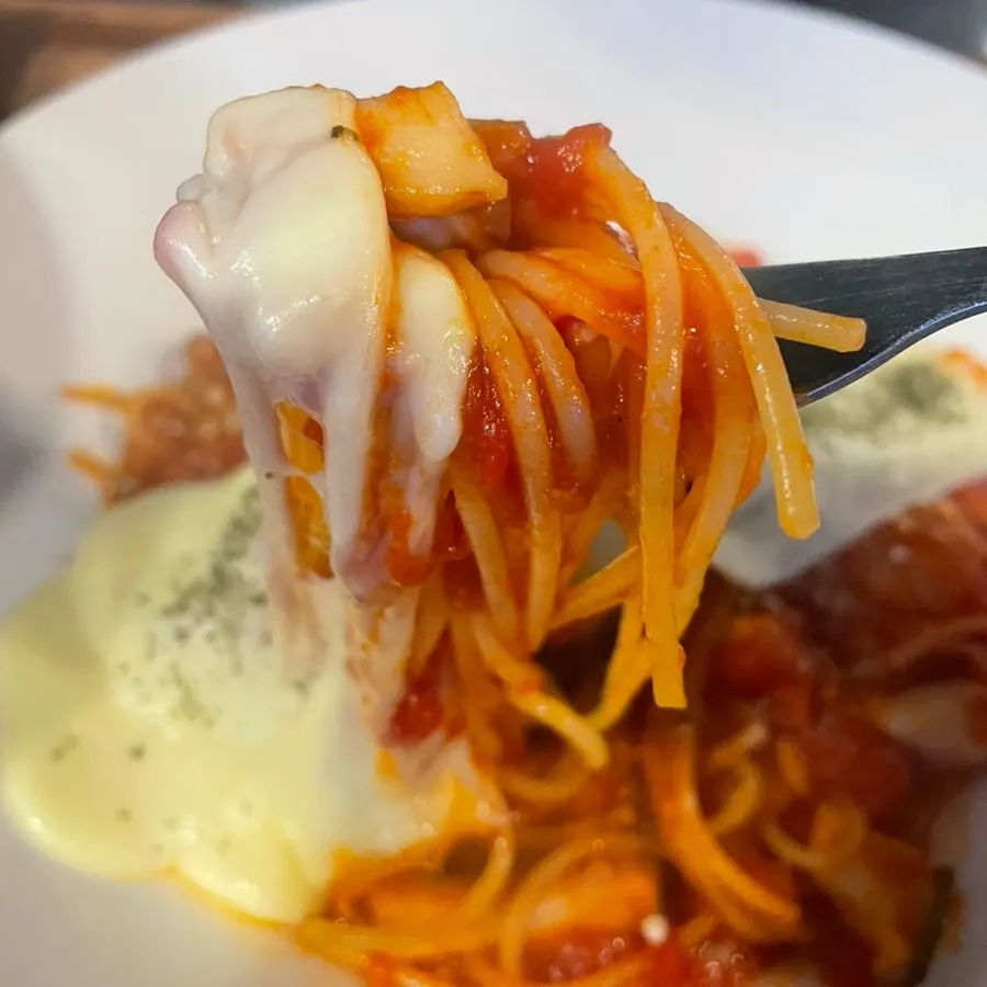 A bite of Tomato Cheese Pasta with stretchy cheese