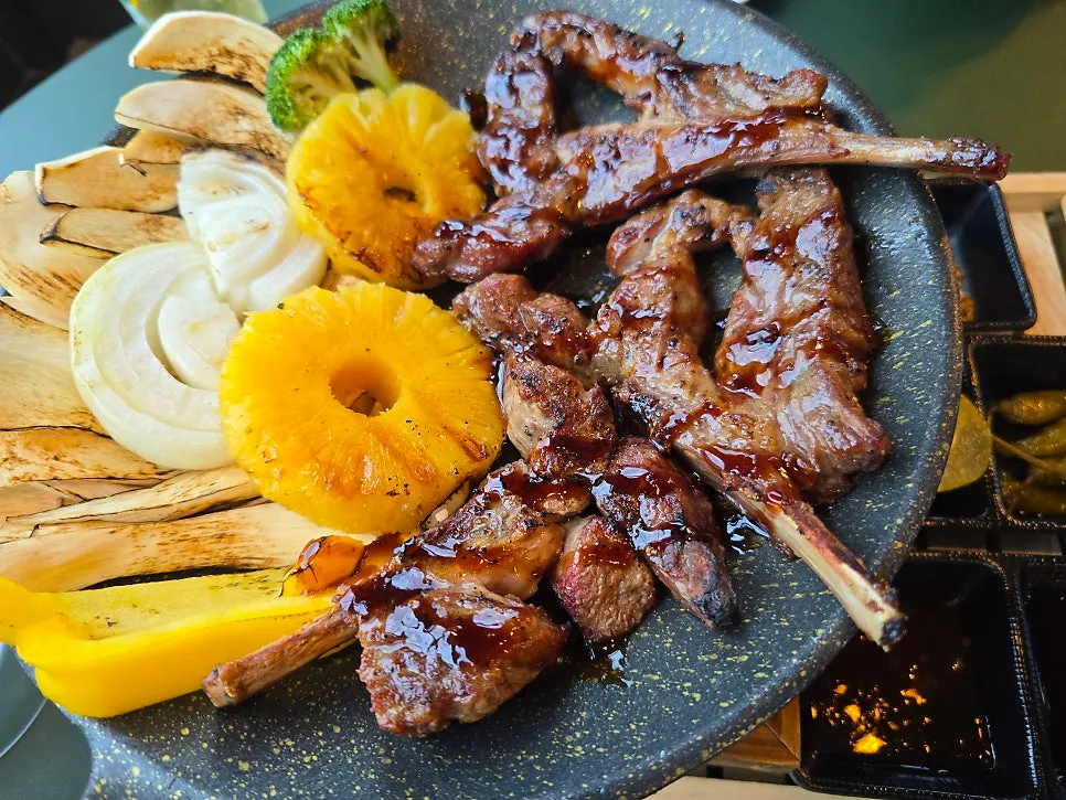 Charcoal-grilled meat plated with side vegetables