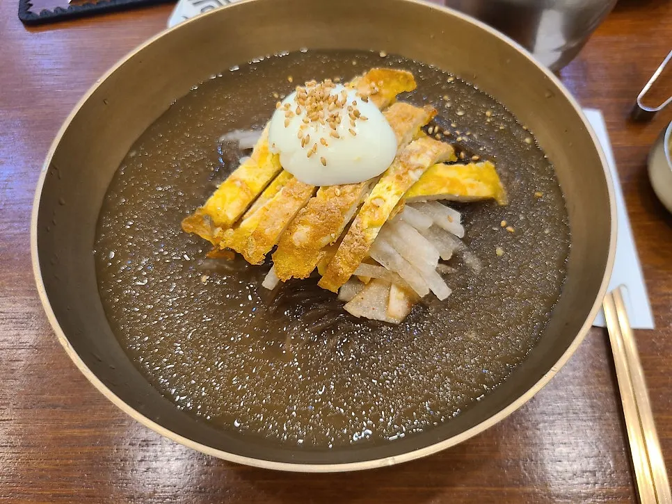 Water naengmyeon topped with shaved ice and pork yukjeon