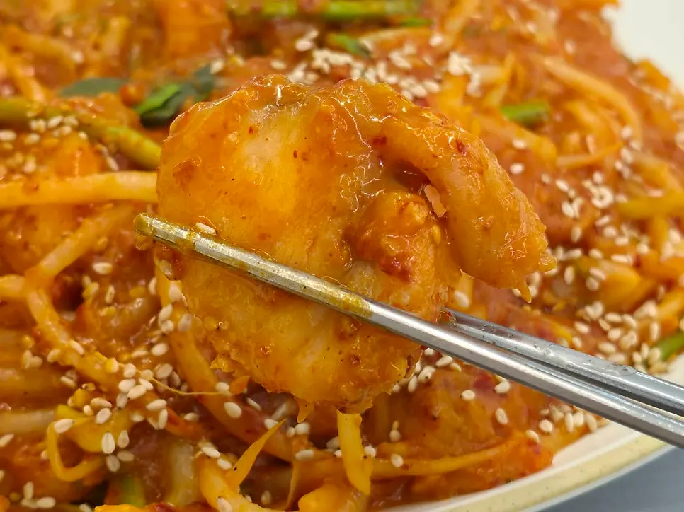 Chopsticks picking up a piece of monkfish meat