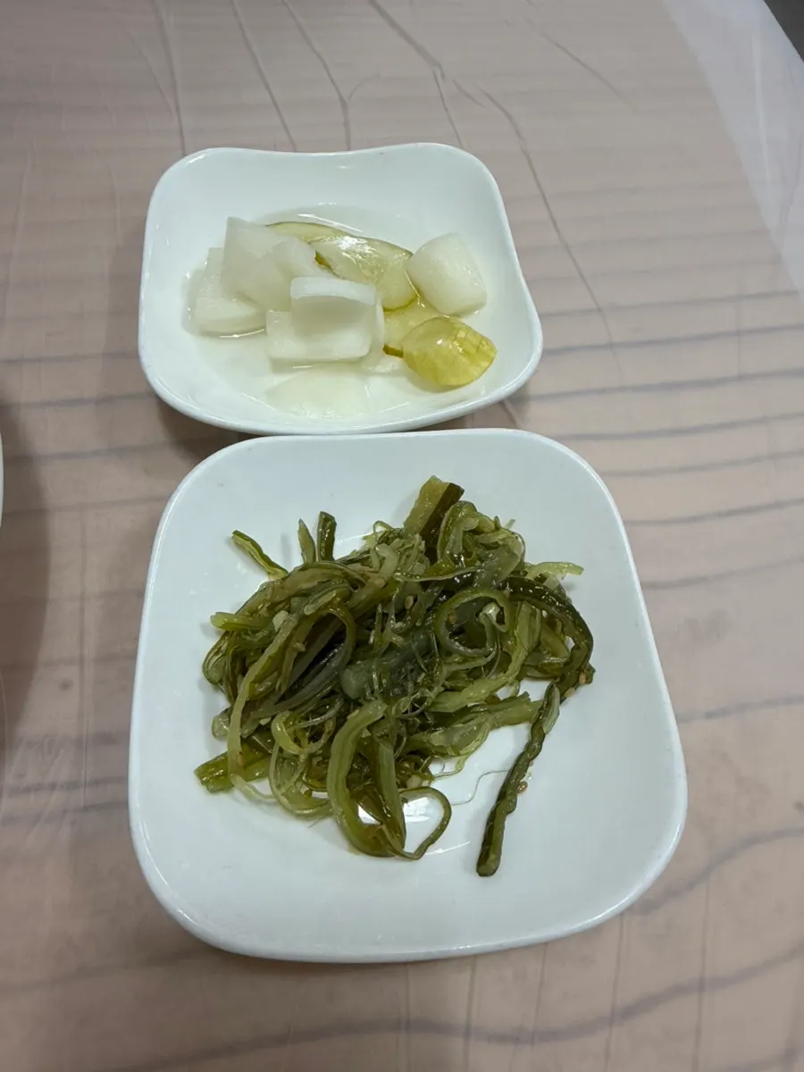 Fully set table of side dishes at Jjimgoeul