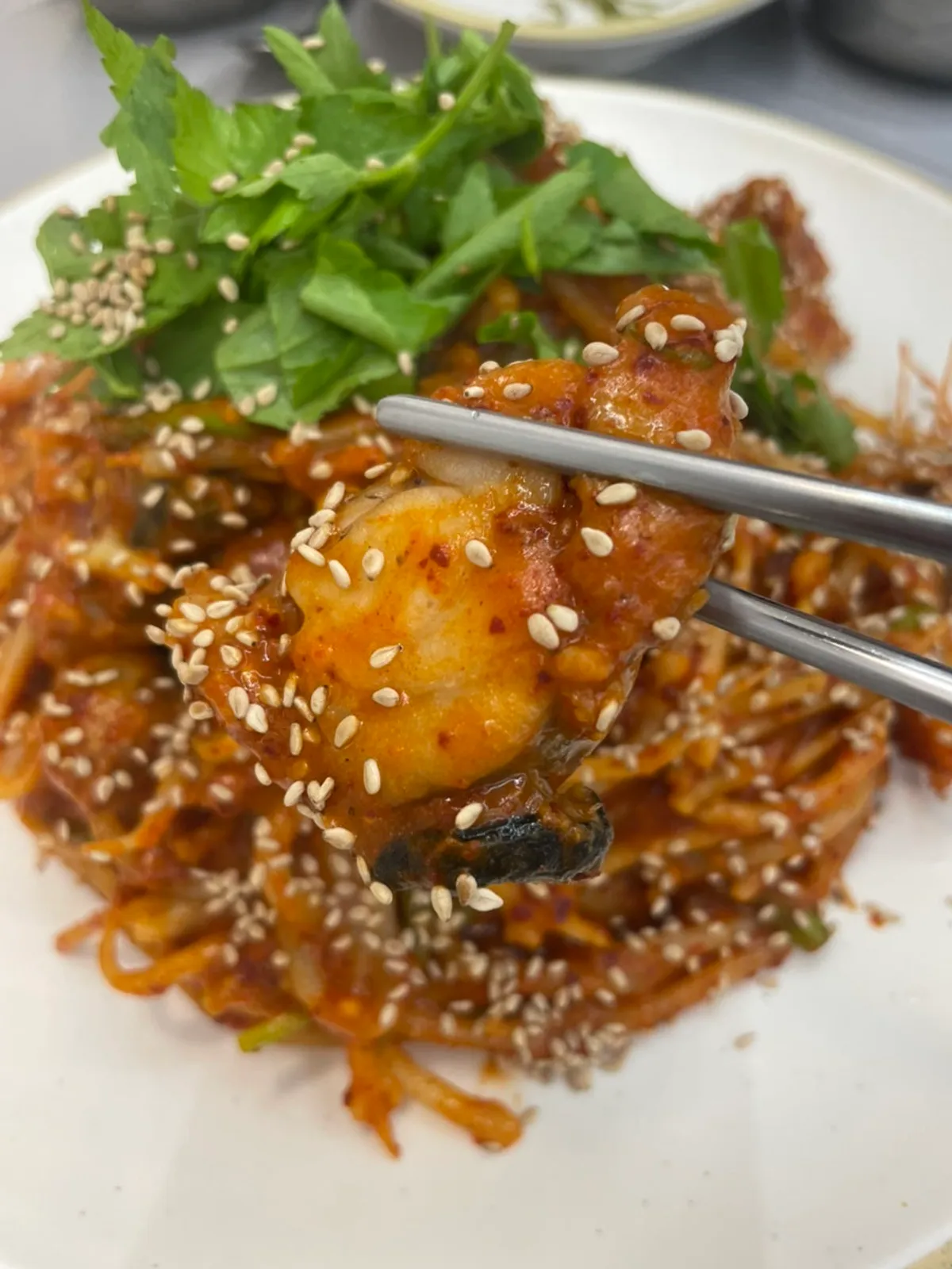 Monkfish and bean sprouts lifted with chopsticks