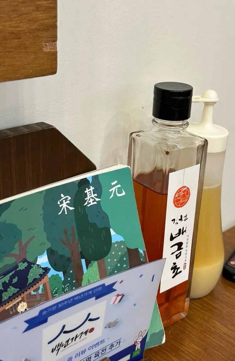 테이블 위 안내 책자와 김천 배금초, 겨자