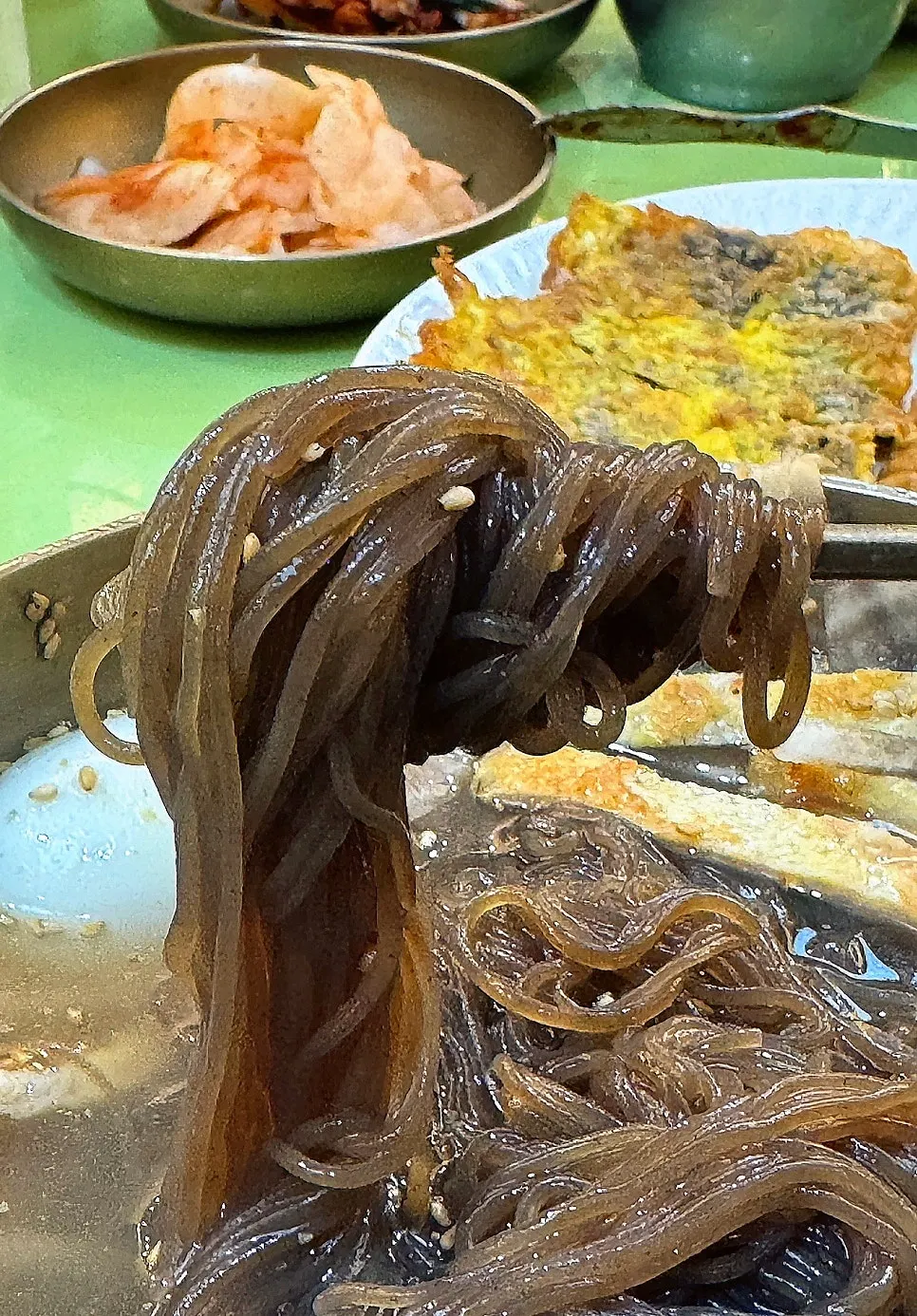 A close-up of the clear mul-naengmyeon broth