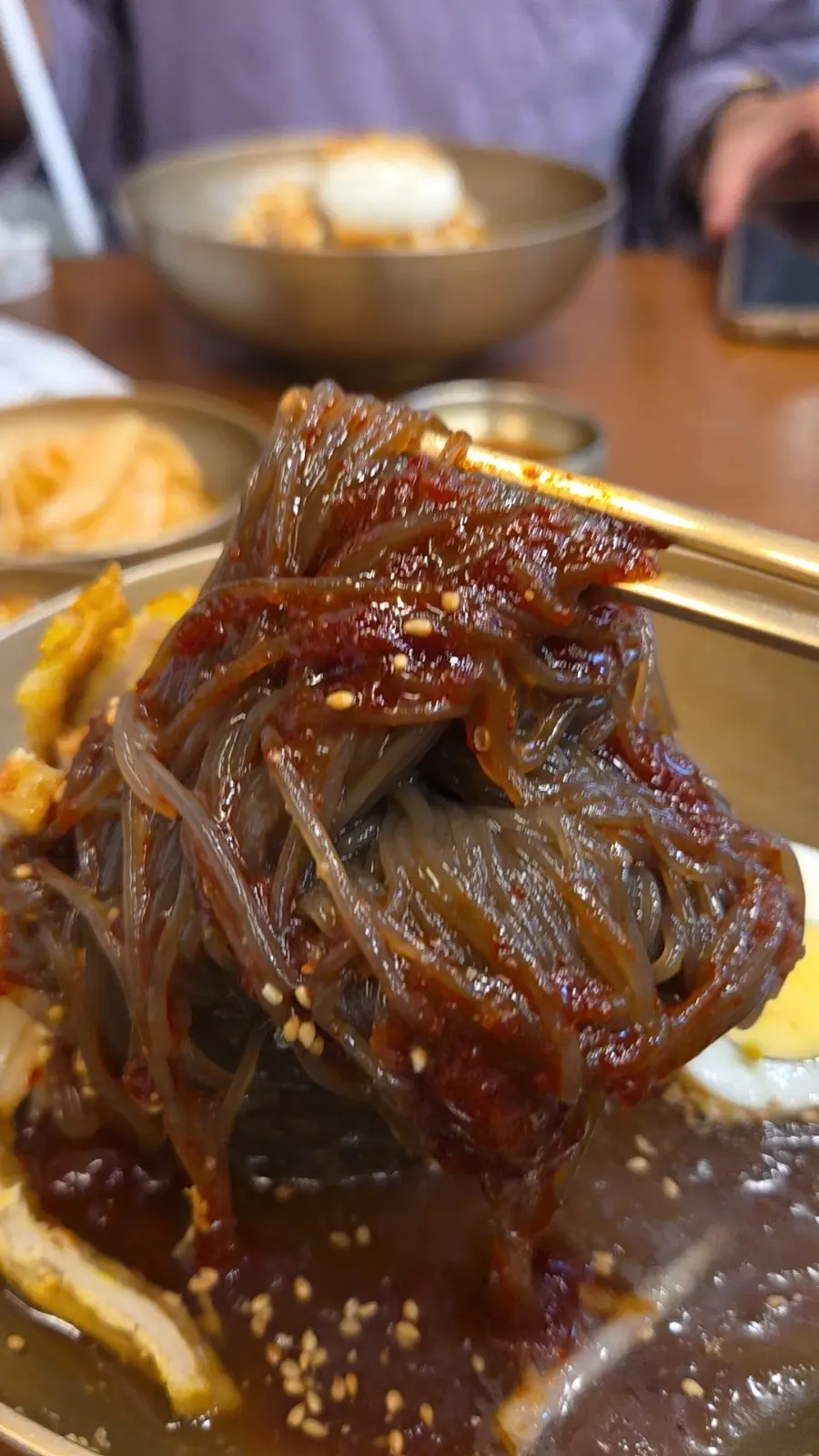 Lifting up the Jeju buckwheat noodles from the mix naengmyeon