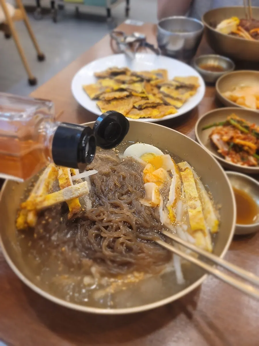Close-up of noodles lifted from the naengmyeon bowl