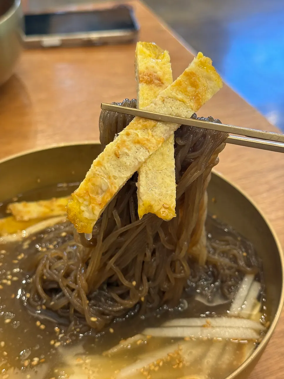 쫄깃한 면발을 들어 올린 물냉면