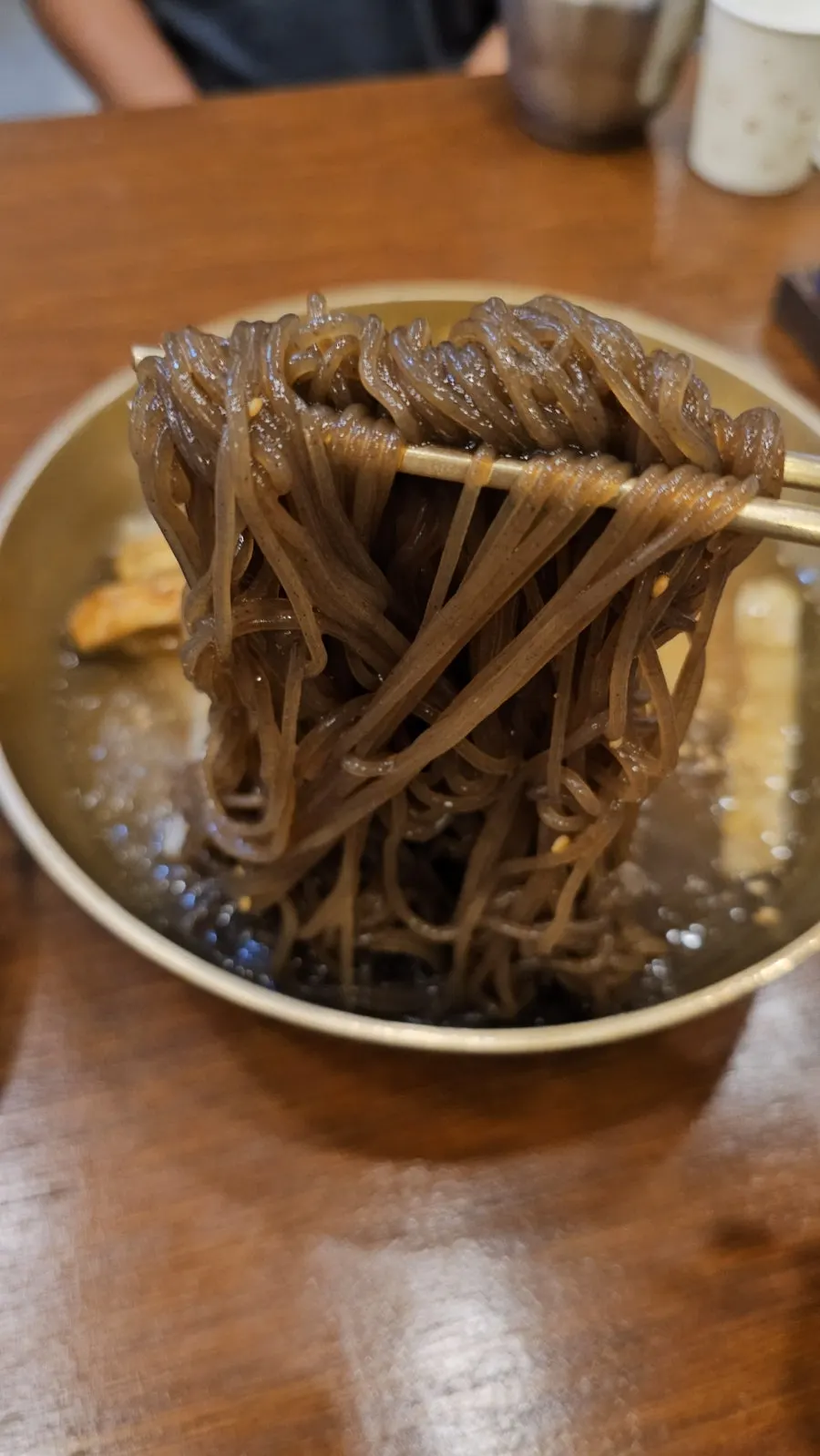 Un tazón de naengmyeon de agua de Jinju con yukjeon de guarnición