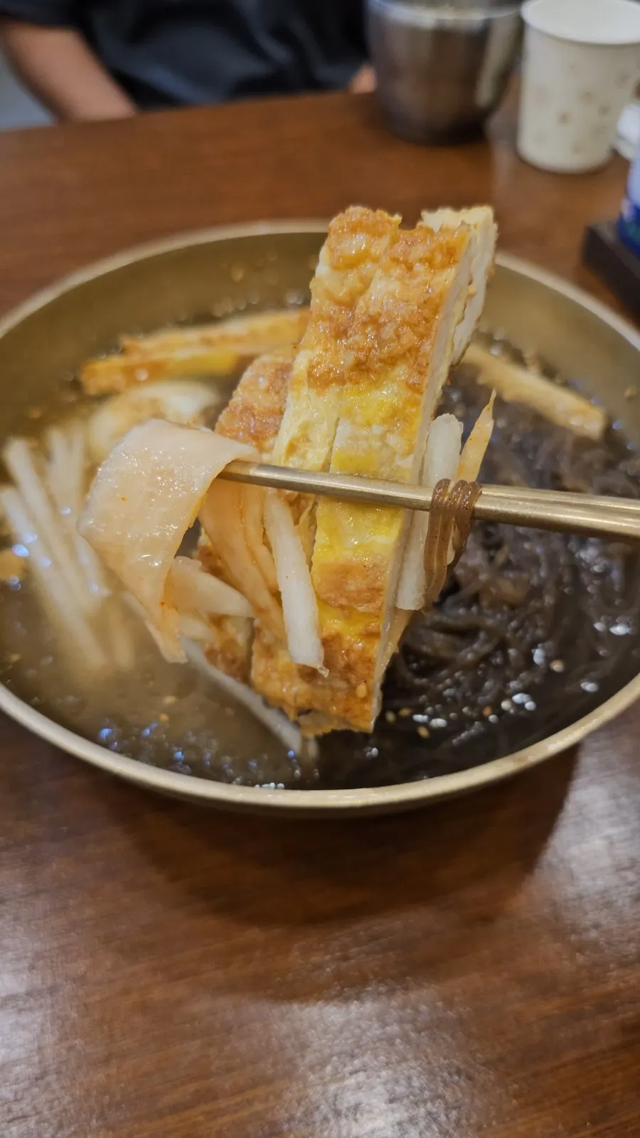 Fideos caseros de trigo sarraceno y rábano encurtido en el naengmyeon de agua