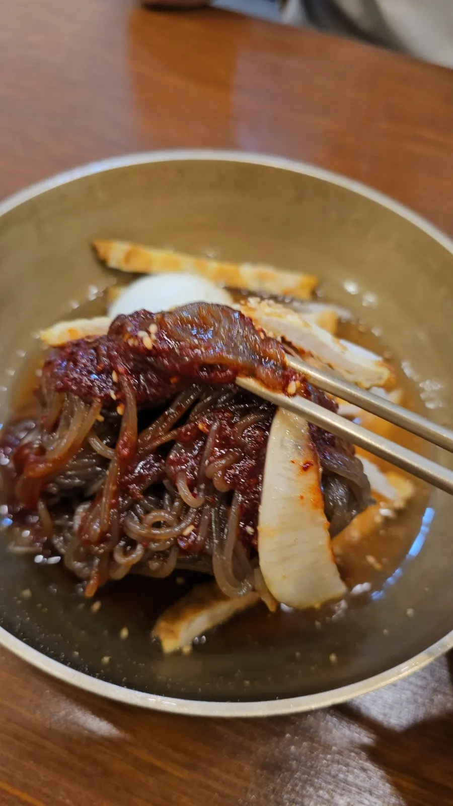 Un tazón de naengmyeon mixto con bastante caldo