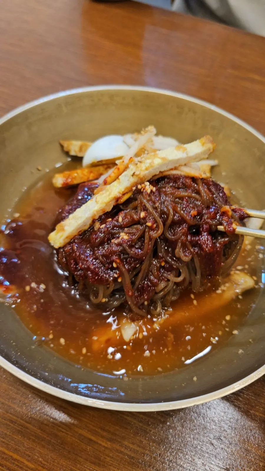 Naengmyeon mixto con abundante salsa condimentada