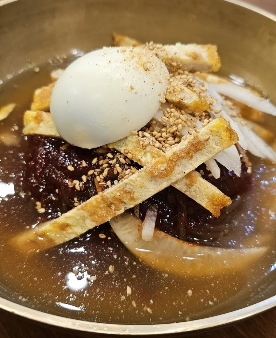 Añadiendo vinagre al naengmyeon