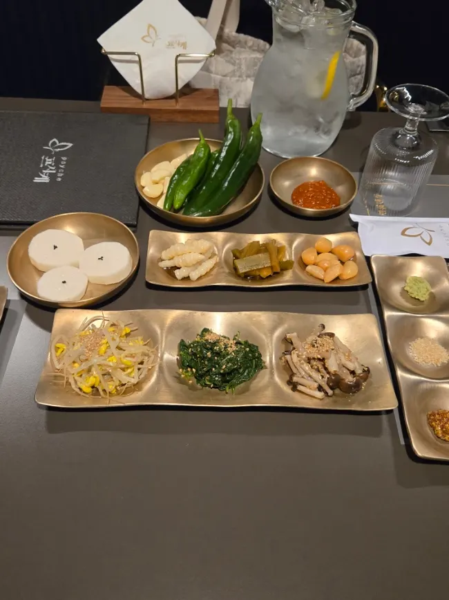 A full spread of Psyche's side dishes in brass bowls
