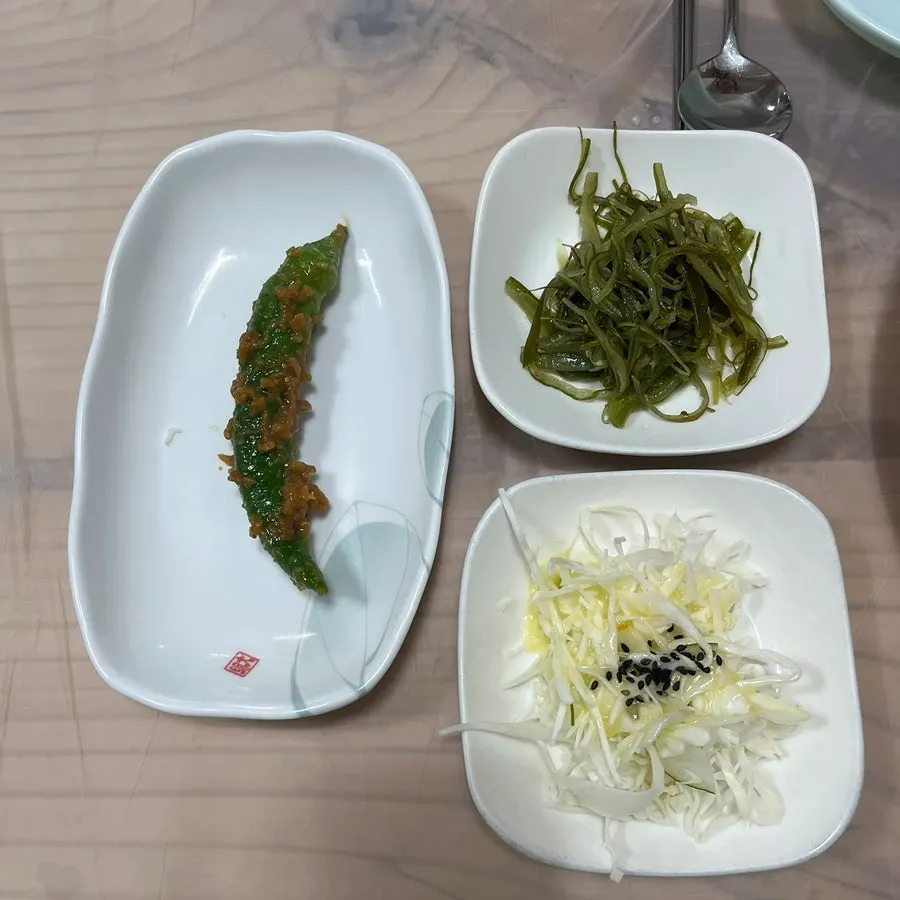 Table setting with basic side dishes and bean sprout soup at Jjimgoeul