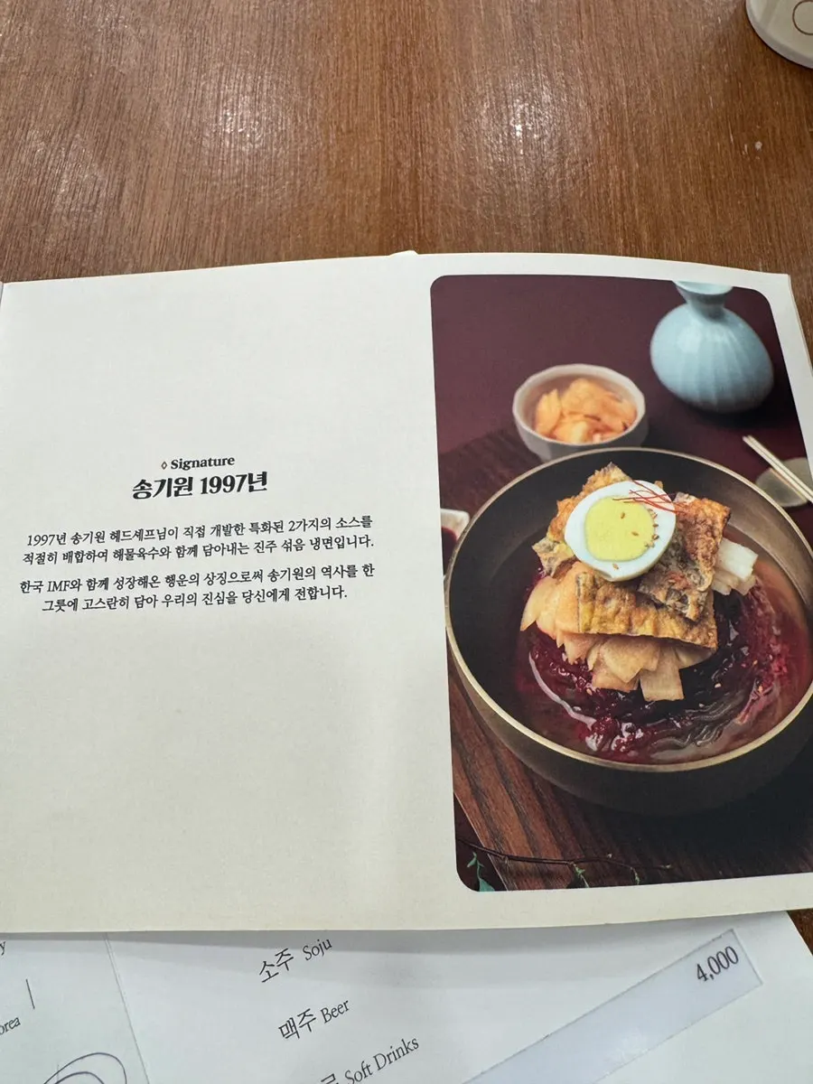 Menu board listing the Sunjo 1800 water naengmyeon and 1997 mixed naengmyeon