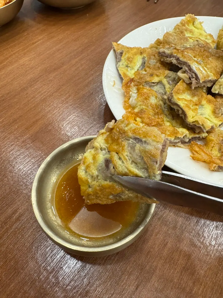 Picking up a piece of ujeon with chopsticks