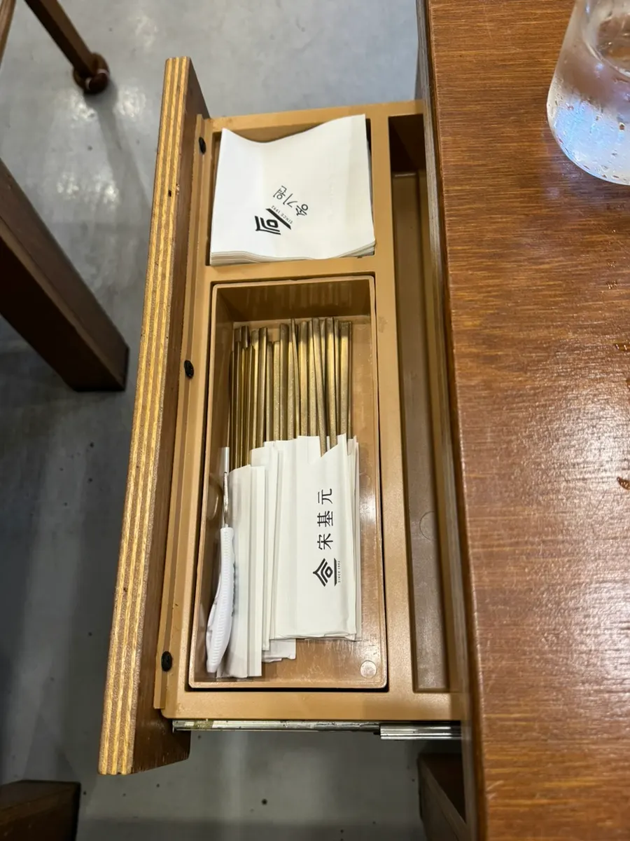 Utensil holder attached to the left side of the table
