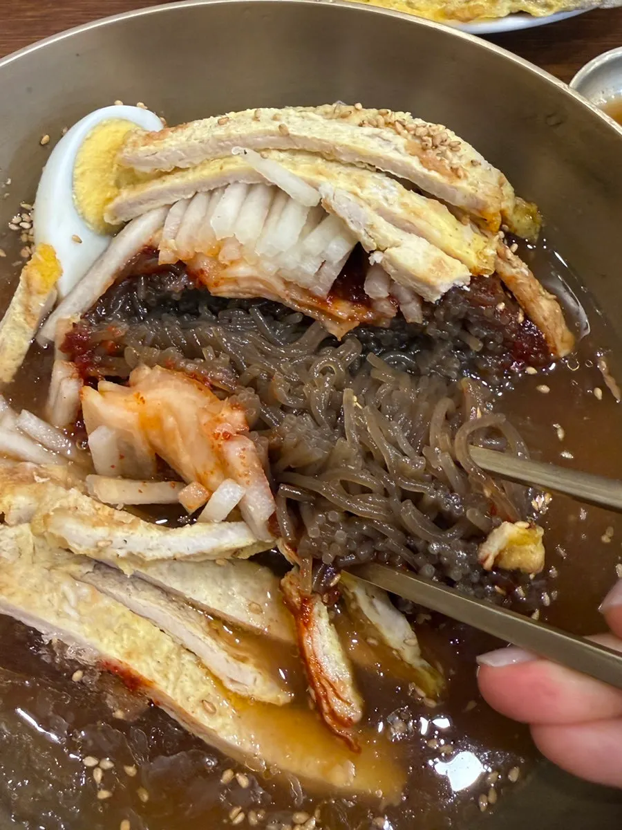 A bite of naengmyeon with yukjeon