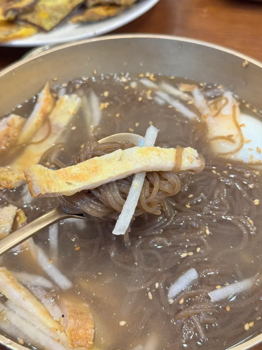 A bite of Jinju naengmyeon with toppings