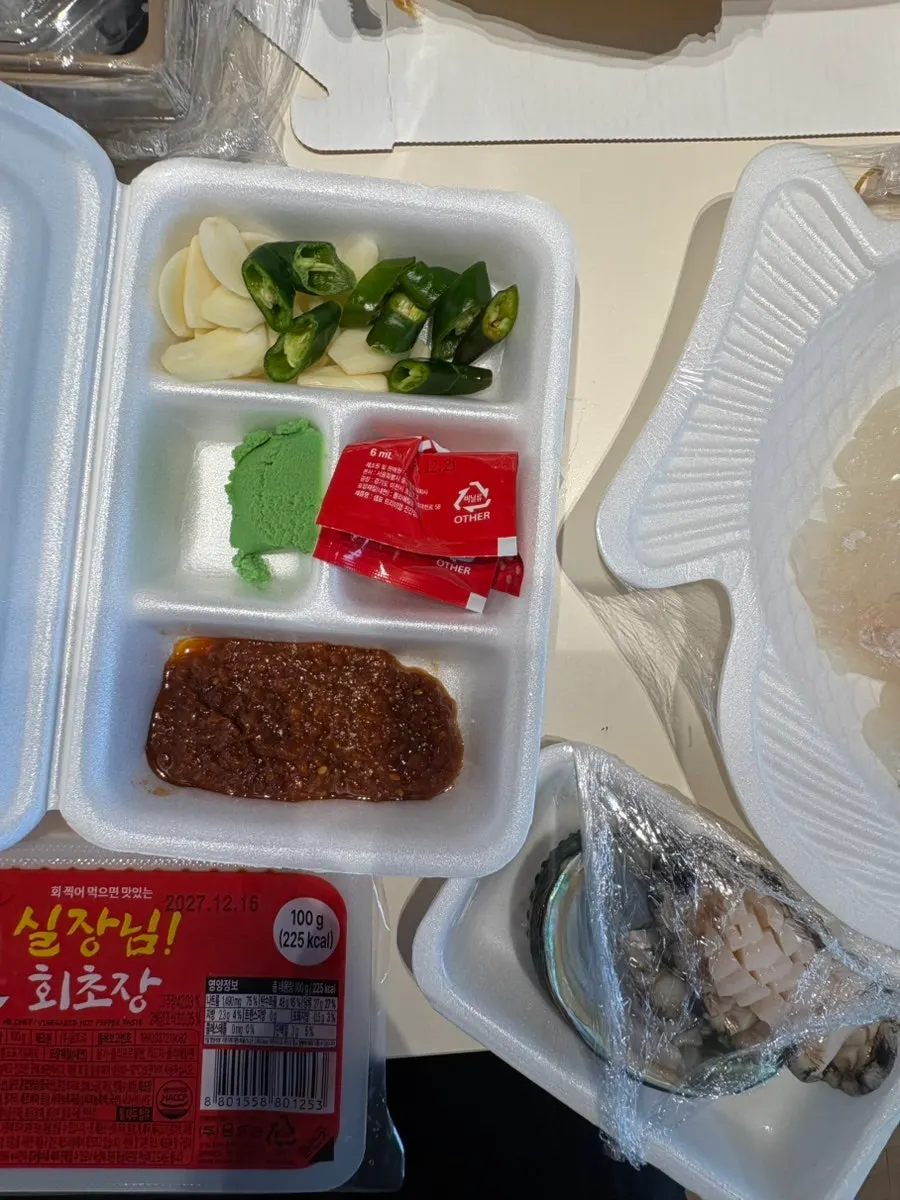 Lettuce and dipping sauces packed alongside the sashimi