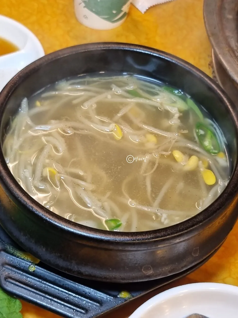 Complimentary bean sprout soup in a hot stone bowl