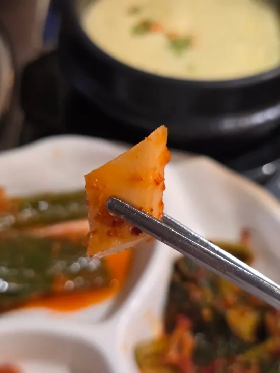 Plate with three kinds of house-made kimchi: scallion, mustard leaf, and altari radish